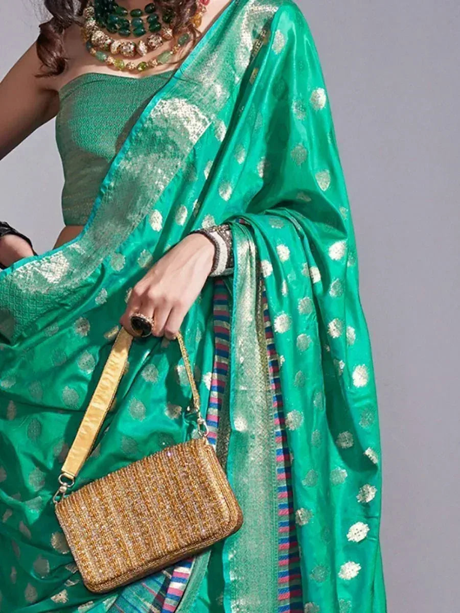 Emerald green saree with gold polka dots, paired with matching blouse and ornate jewelry, perfect for Indian ethnic wear occasions.