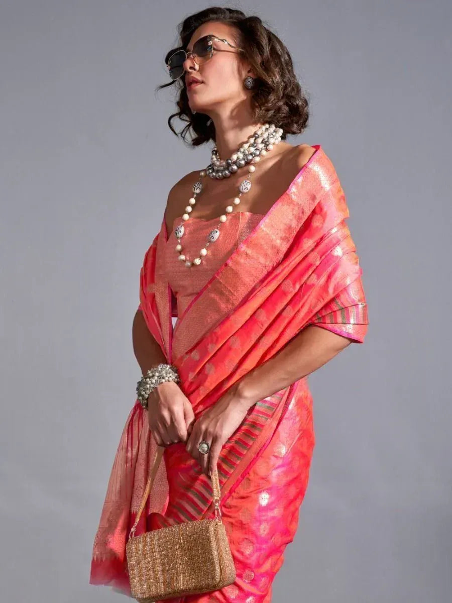 Woman in vibrant pink designer saree with pearl jewelry and sunglasses, ethnic Indian wear