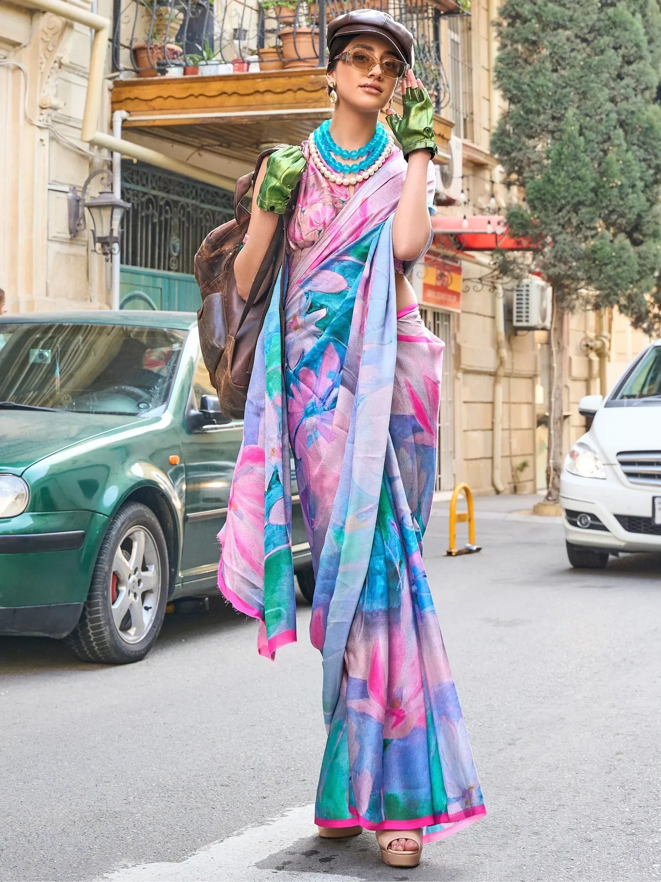 Woman in colorful floral saree with green gloves and cap, street style ethnic wear