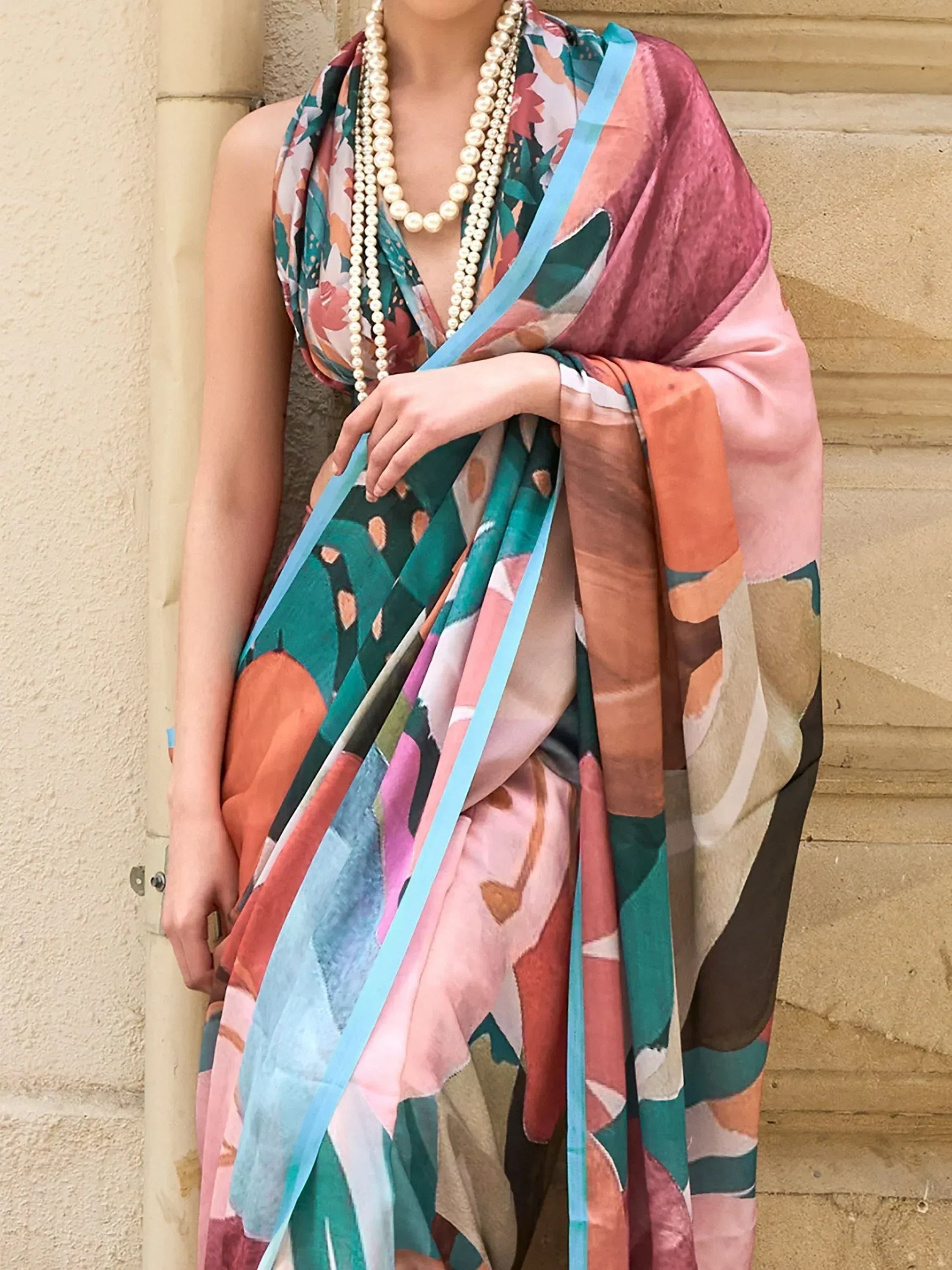 Woman wearing colorful floral printed saree with pearl necklace, ethnic Indian fashion