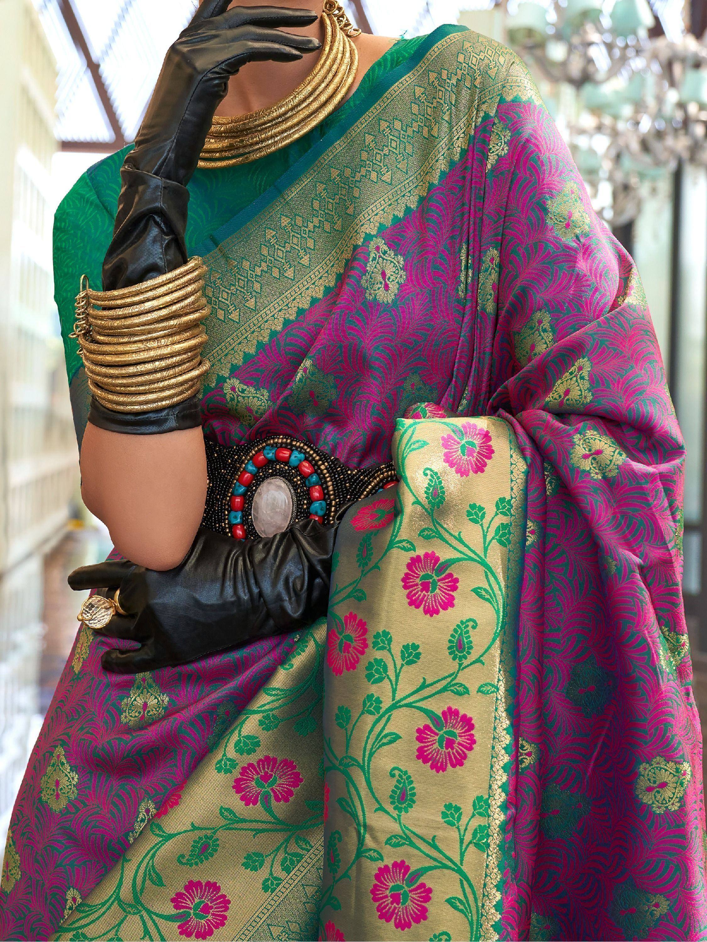 Elegant green and pink floral saree with gold border, paired with black gloves and statement jewelry.