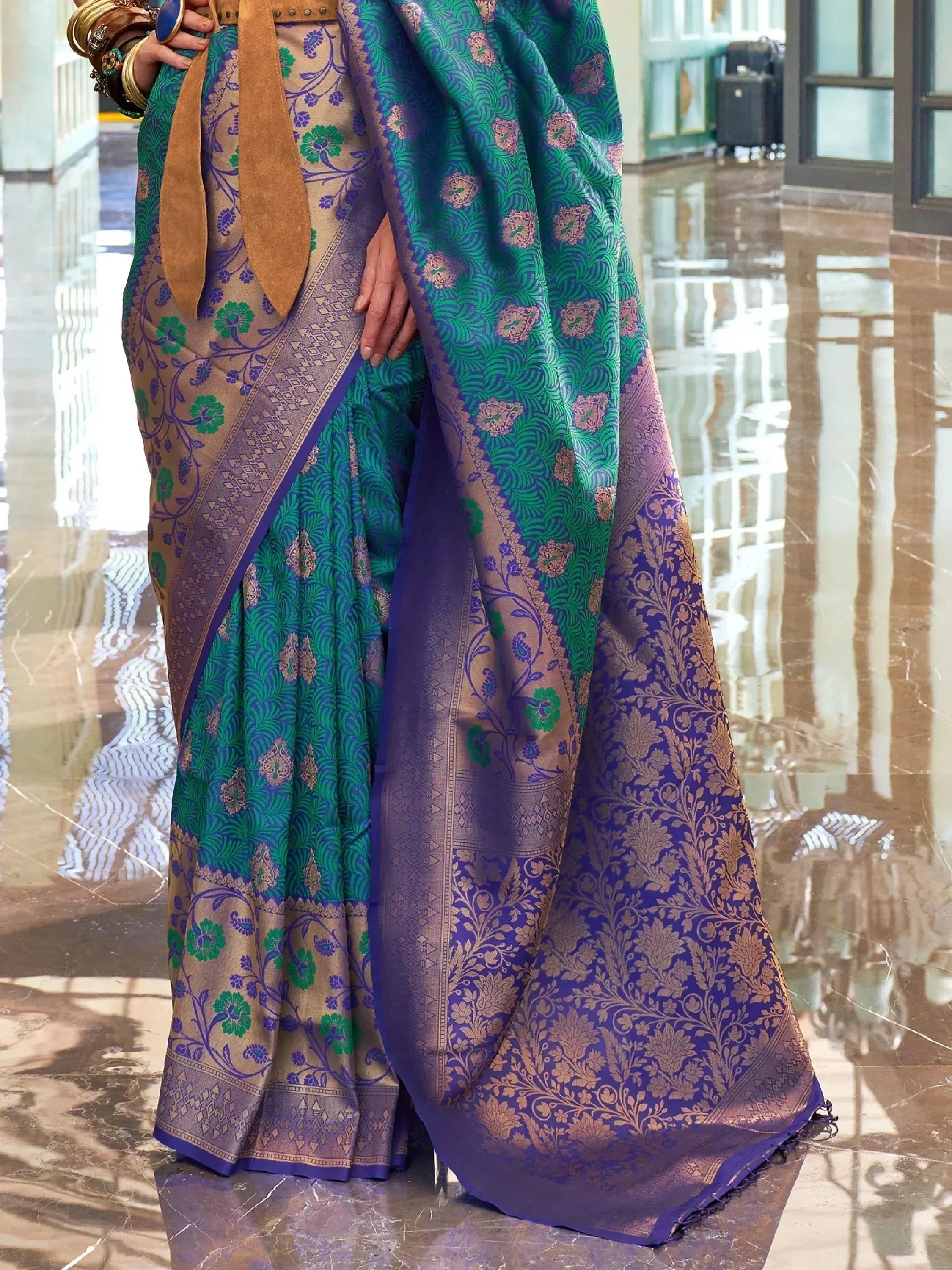 Elegant green and purple designer saree with intricate floral patterns and golden zari work, perfect for ethnic occasions.
