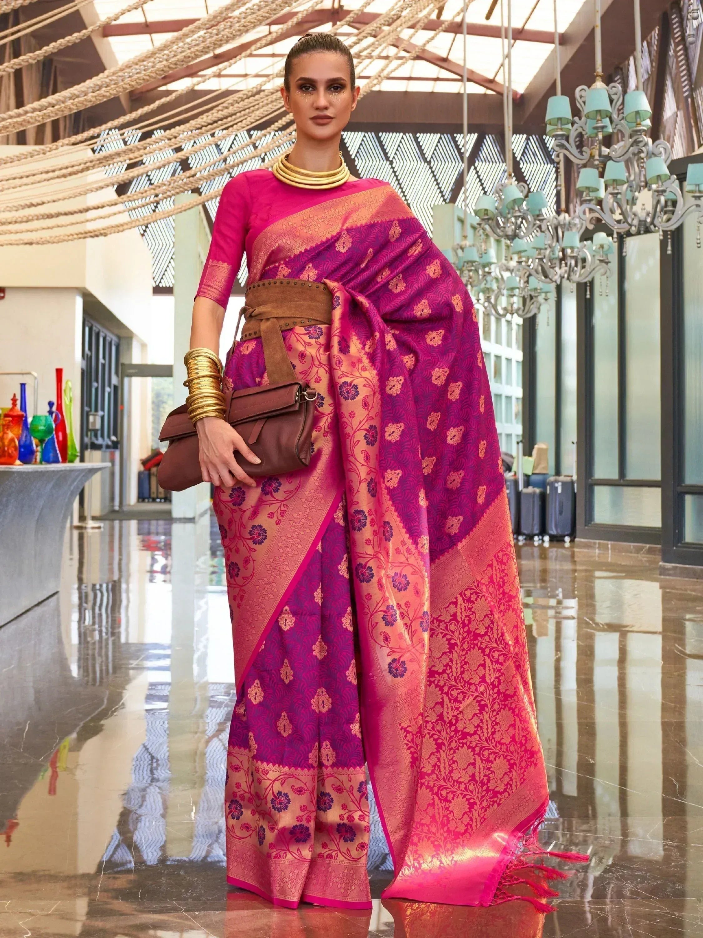 Vibrant pink and purple floral saree with gold zari, styled with belt and gold jewelry for ethnic occasions
