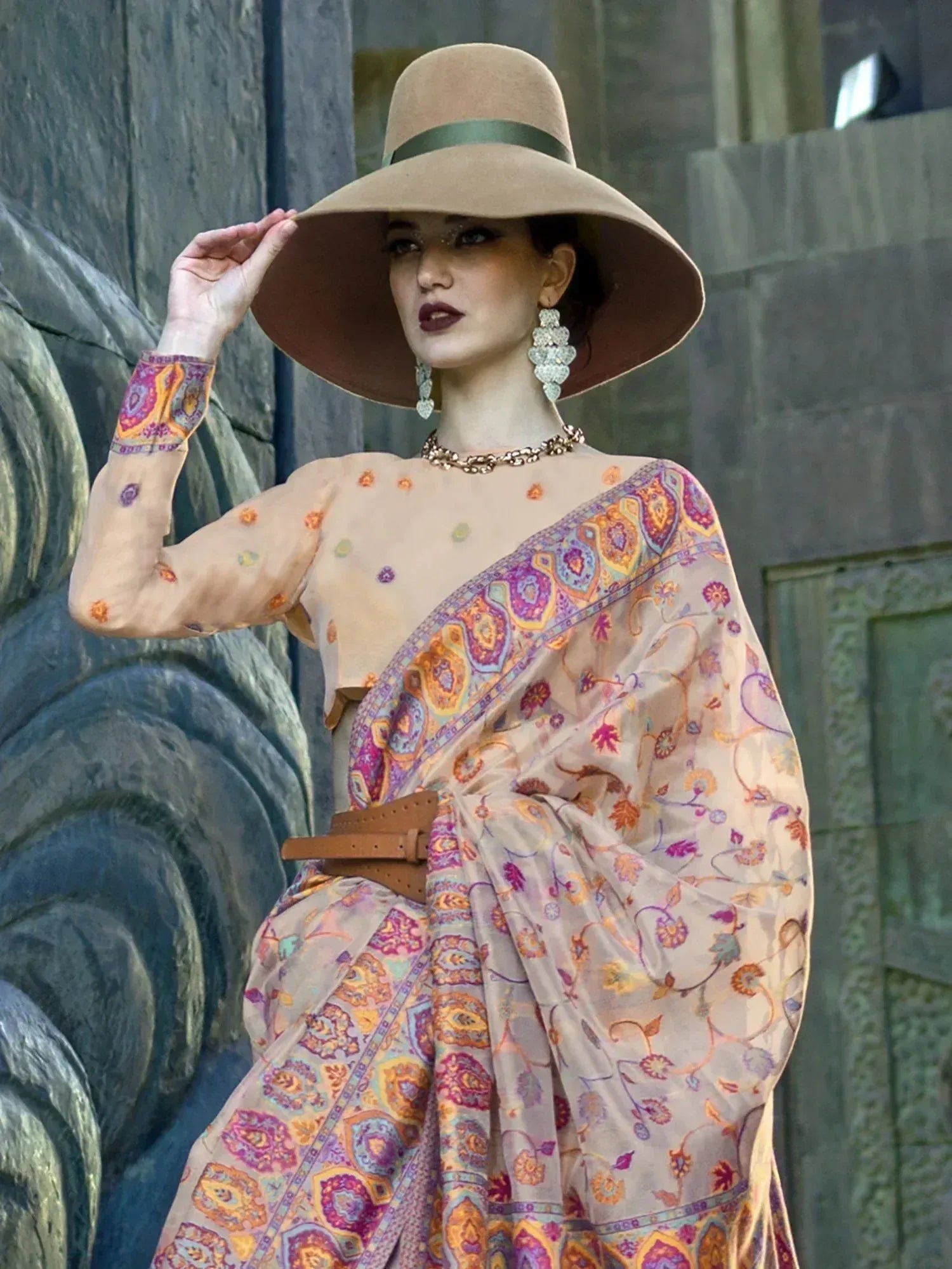 Woman in colorful printed saree with wide-brim hat, ethnic wear for festive occasions