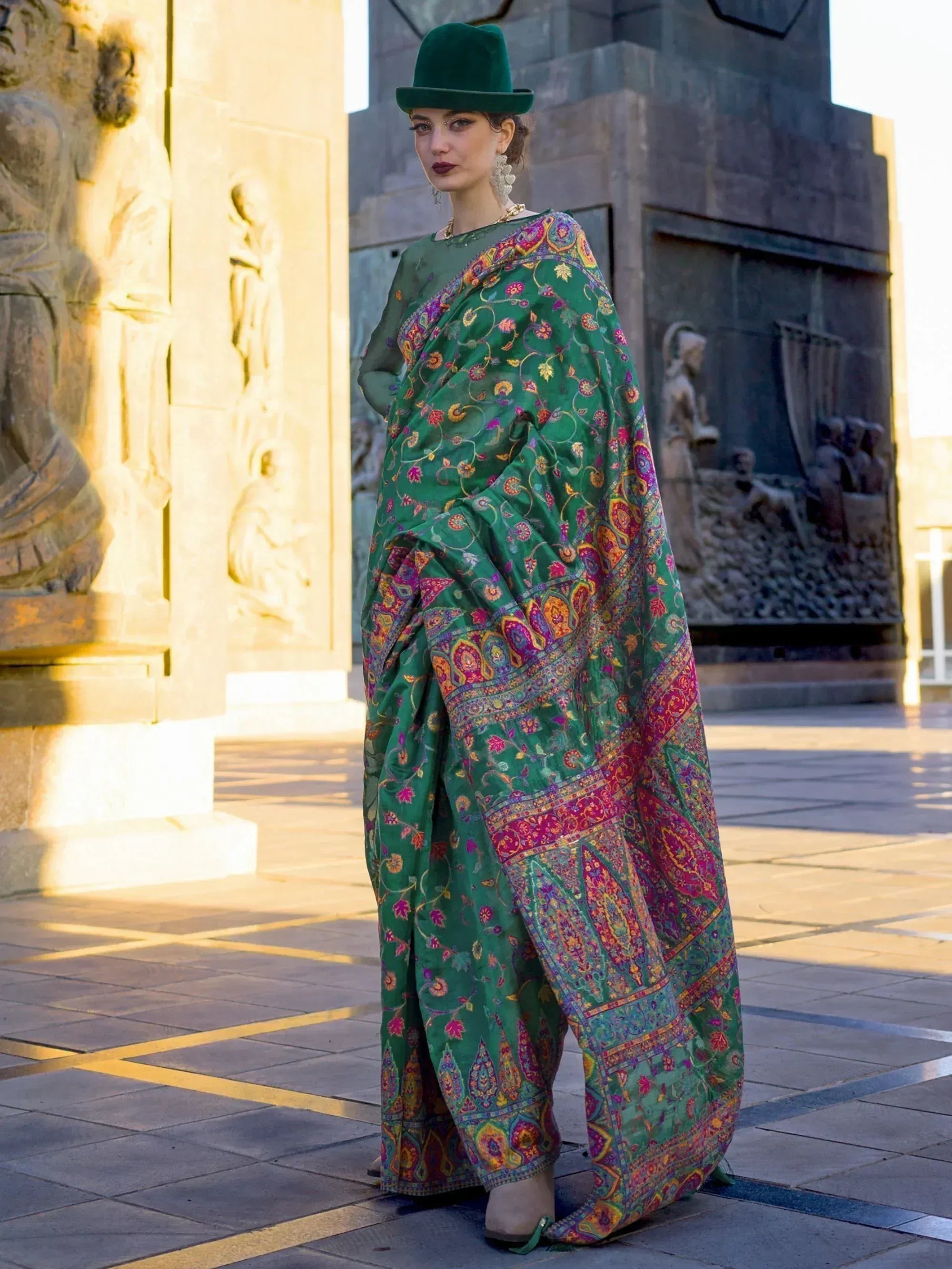 Woman in green floral printed saree with matching hat, styled for ethnic wear occasions
