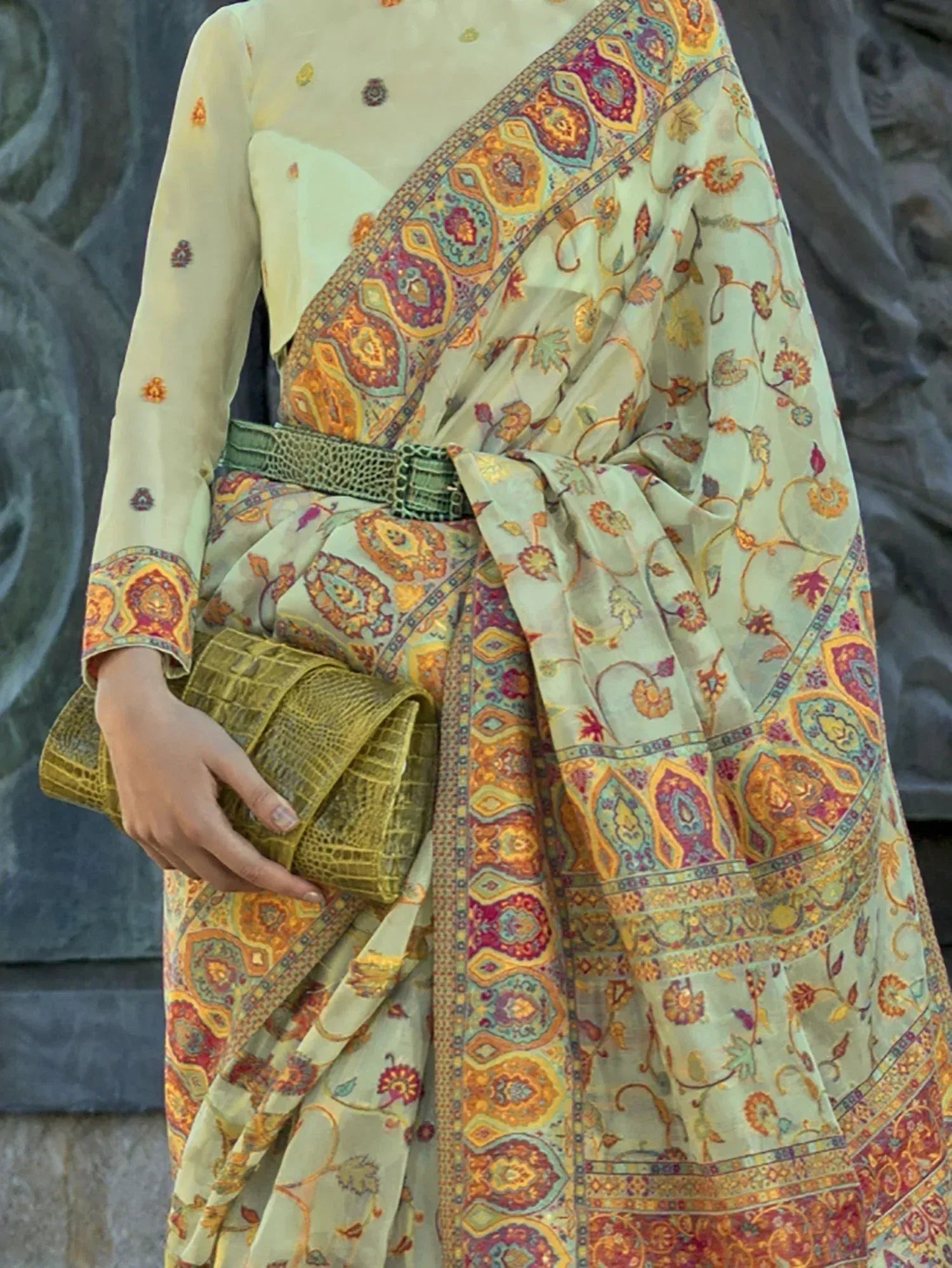 Elegant printed saree with floral paisley design, paired with matching blouse and green belt, perfect for ethnic occasions.