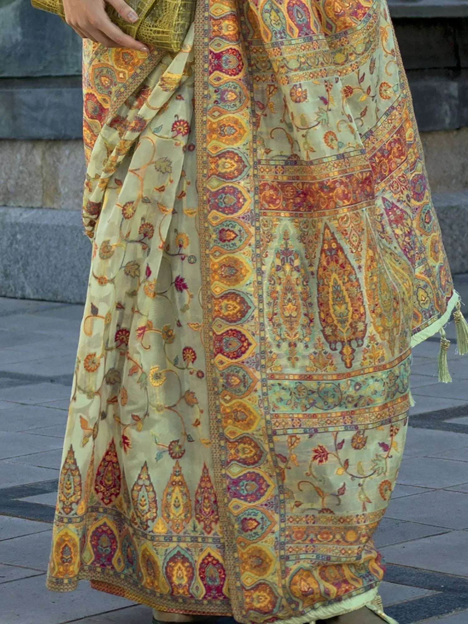 Elegant Indian saree with intricate paisley and floral print in mustard, red, and green tones