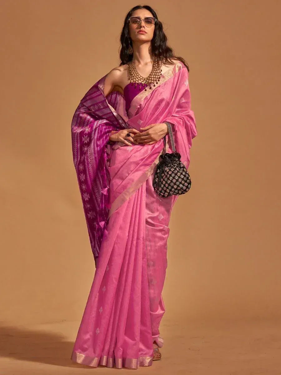 Pink designer saree with purple border, ethnic wear for women, styled with statement jewelry and handbag