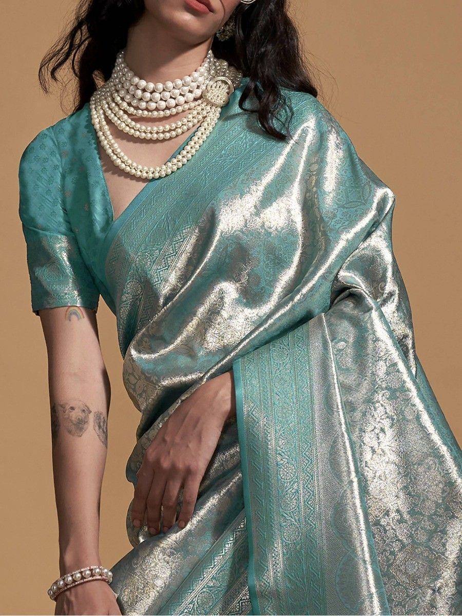 Teal designer saree with gold zari work, paired with pearl jewelry for ethnic wear