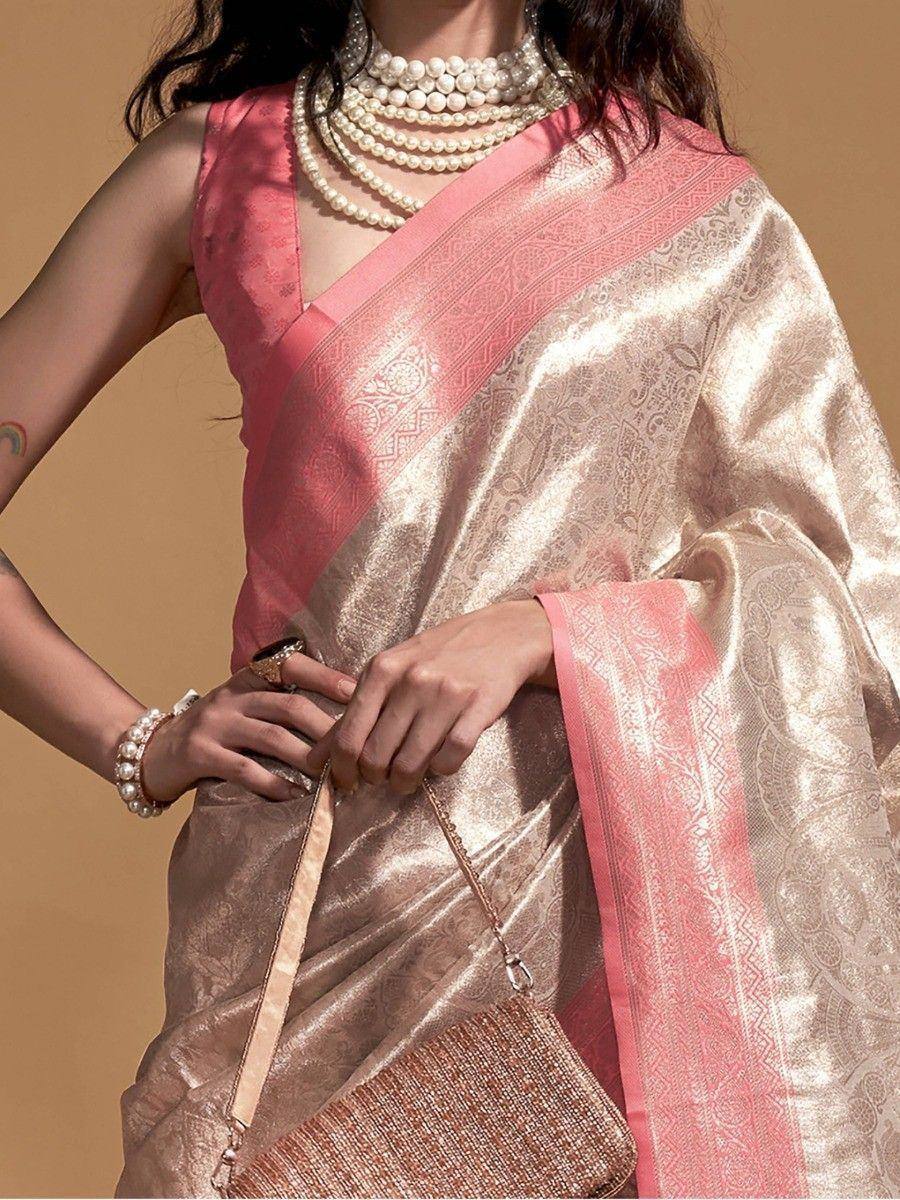 Elegant gold and pink designer saree with intricate weave, paired with pearl jewelry for ethnic occasions