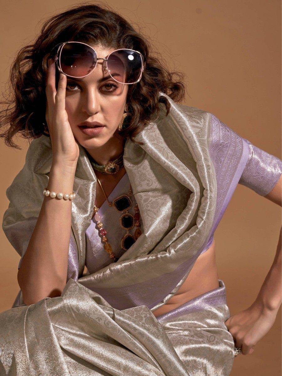 Stylish woman in lavender and silver saree with statement jewelry and sunglasses