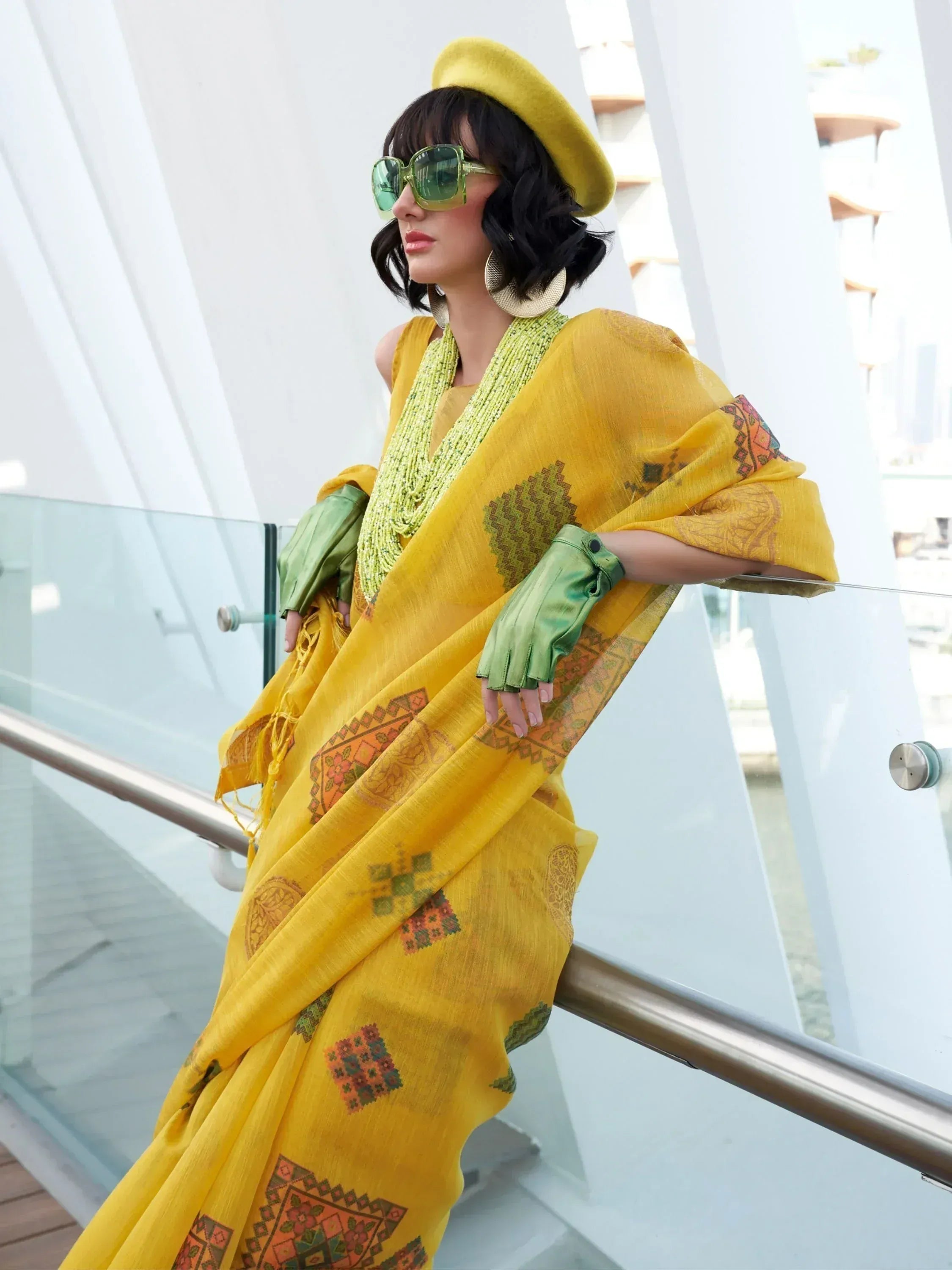 Stylish yellow ethnic saree with geometric print, green accessories, and matching beret for modern Indian wear