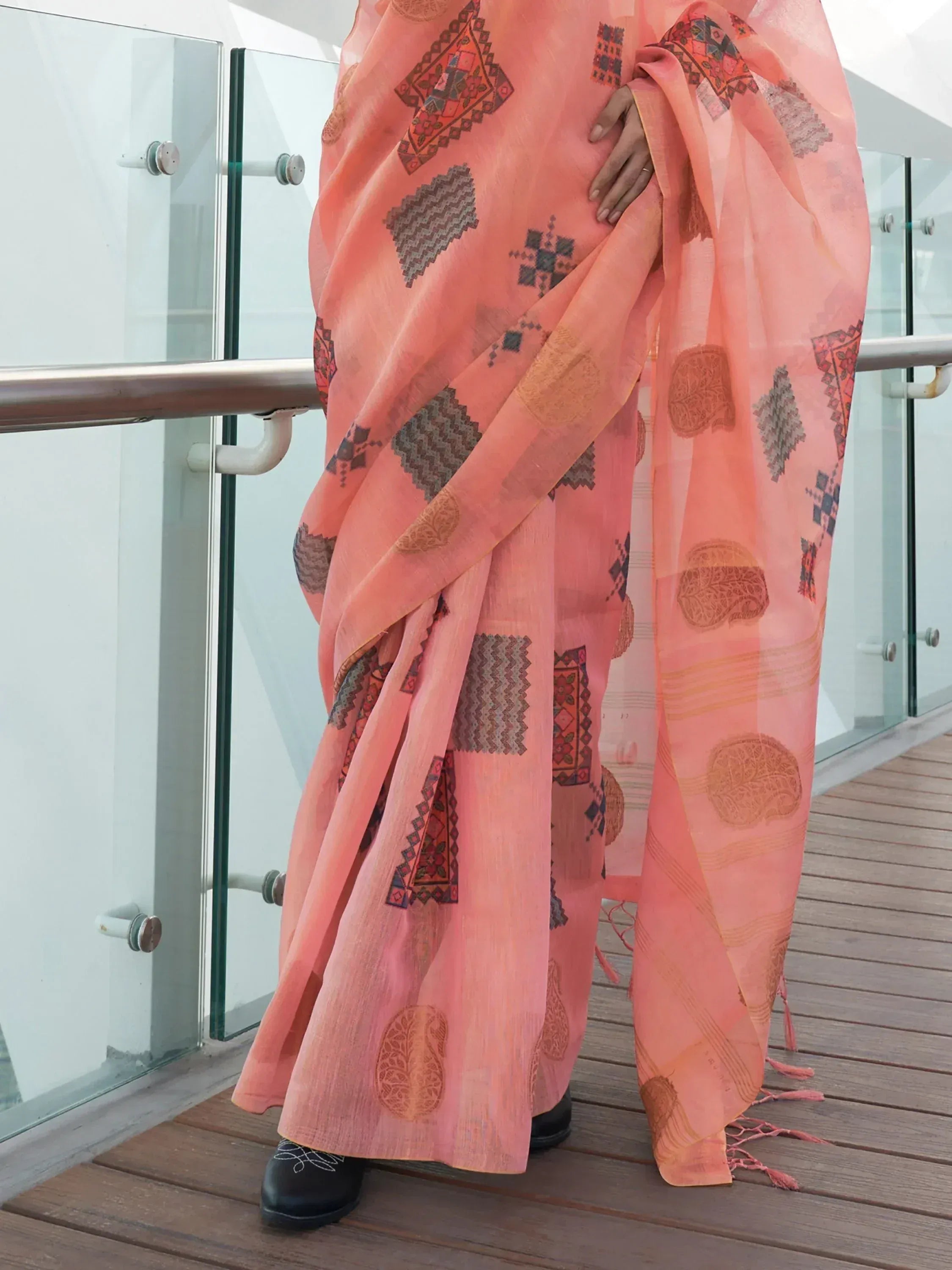 Peach ethnic saree with geometric and paisley prints, styled on a balcony