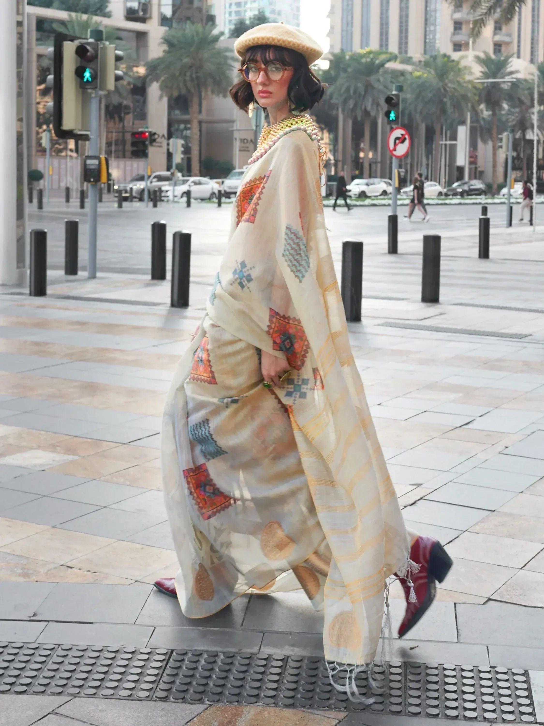 Woman in ethnic printed gown with beret, walking city street, stylish Indian wear
