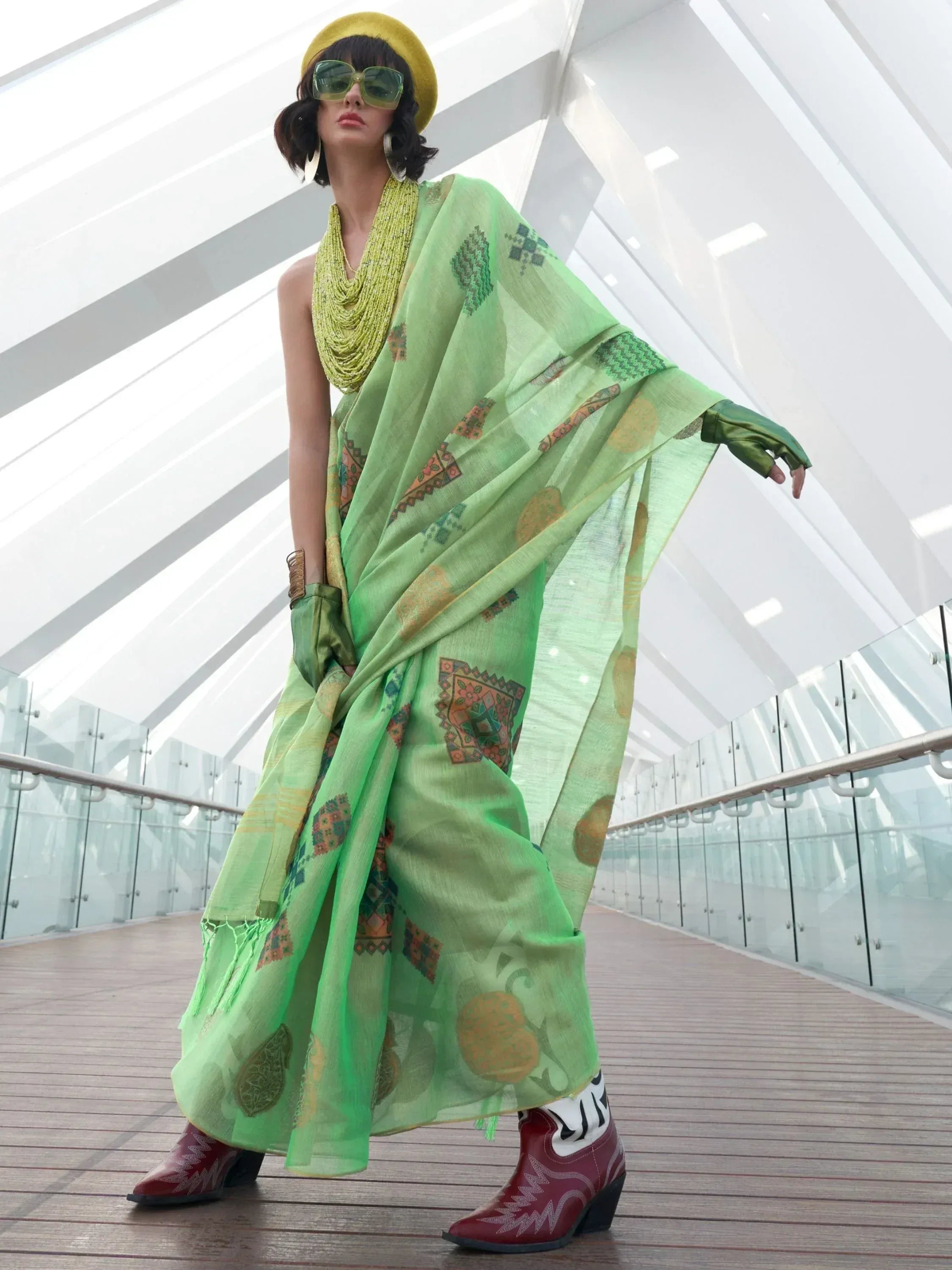 Stylish green printed saree with yellow hat and cowboy boots, modern ethnic wear