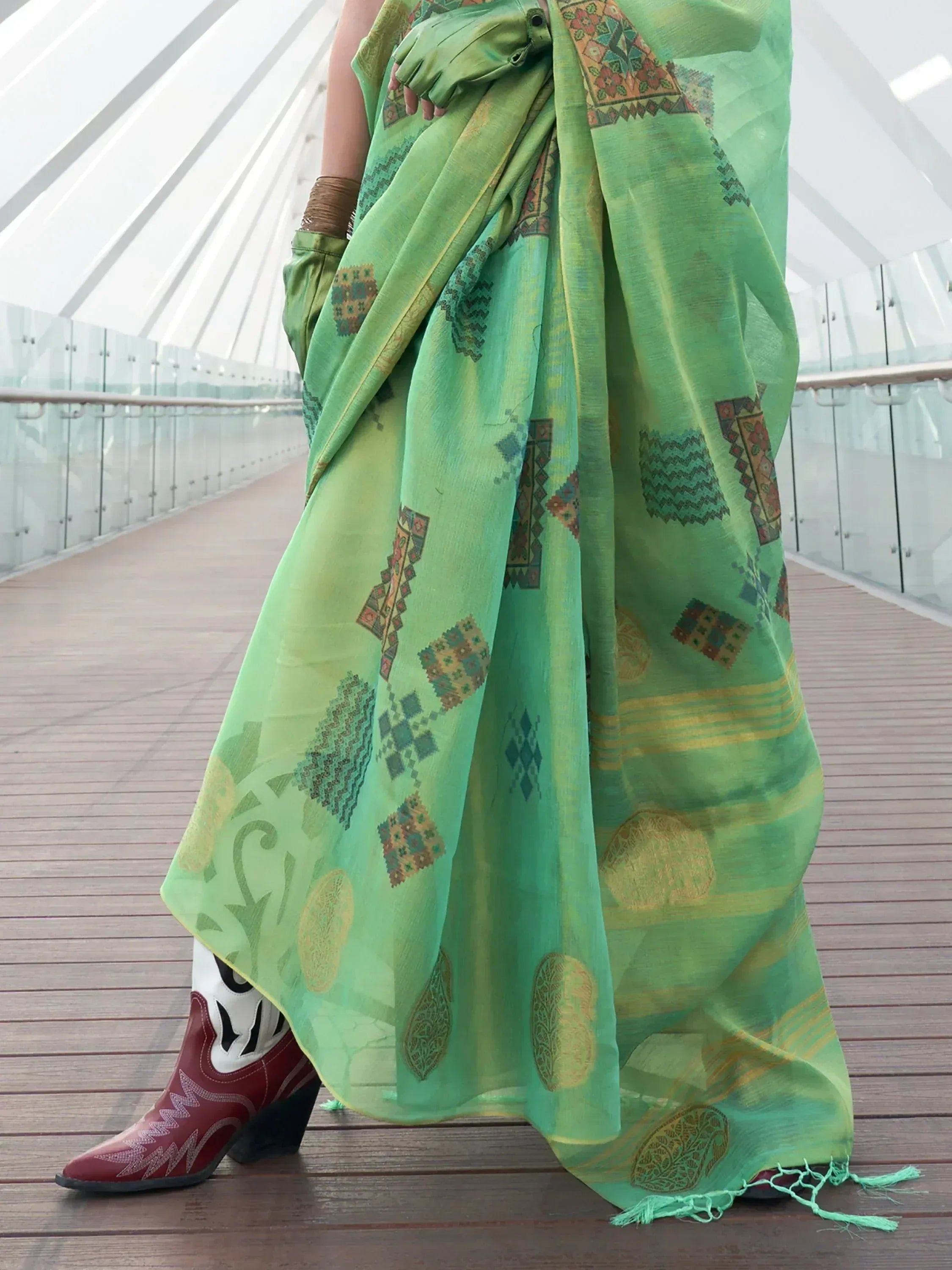 Green printed saree with geometric motifs, paired with cowboy boots, modern ethnic wear