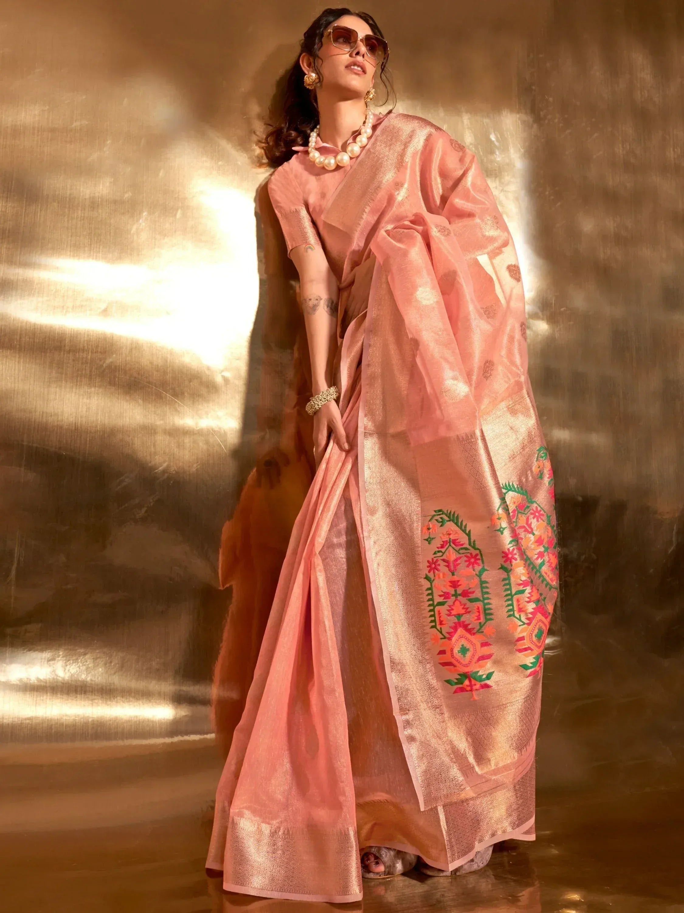 Pink embroidered saree with gold border, styled with pearl necklace and sunglasses for ethnic wear