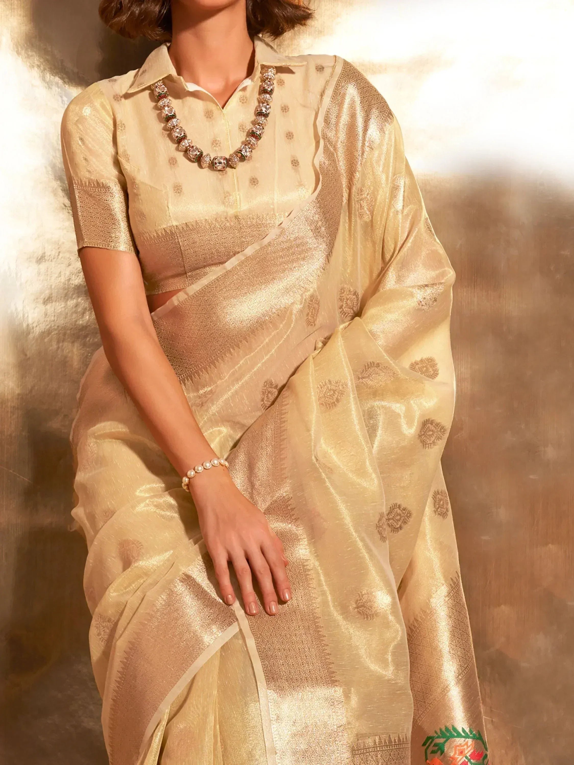 Elegant beige saree with intricate woven patterns and matching blouse, perfect for Indian ethnic wear occasions.