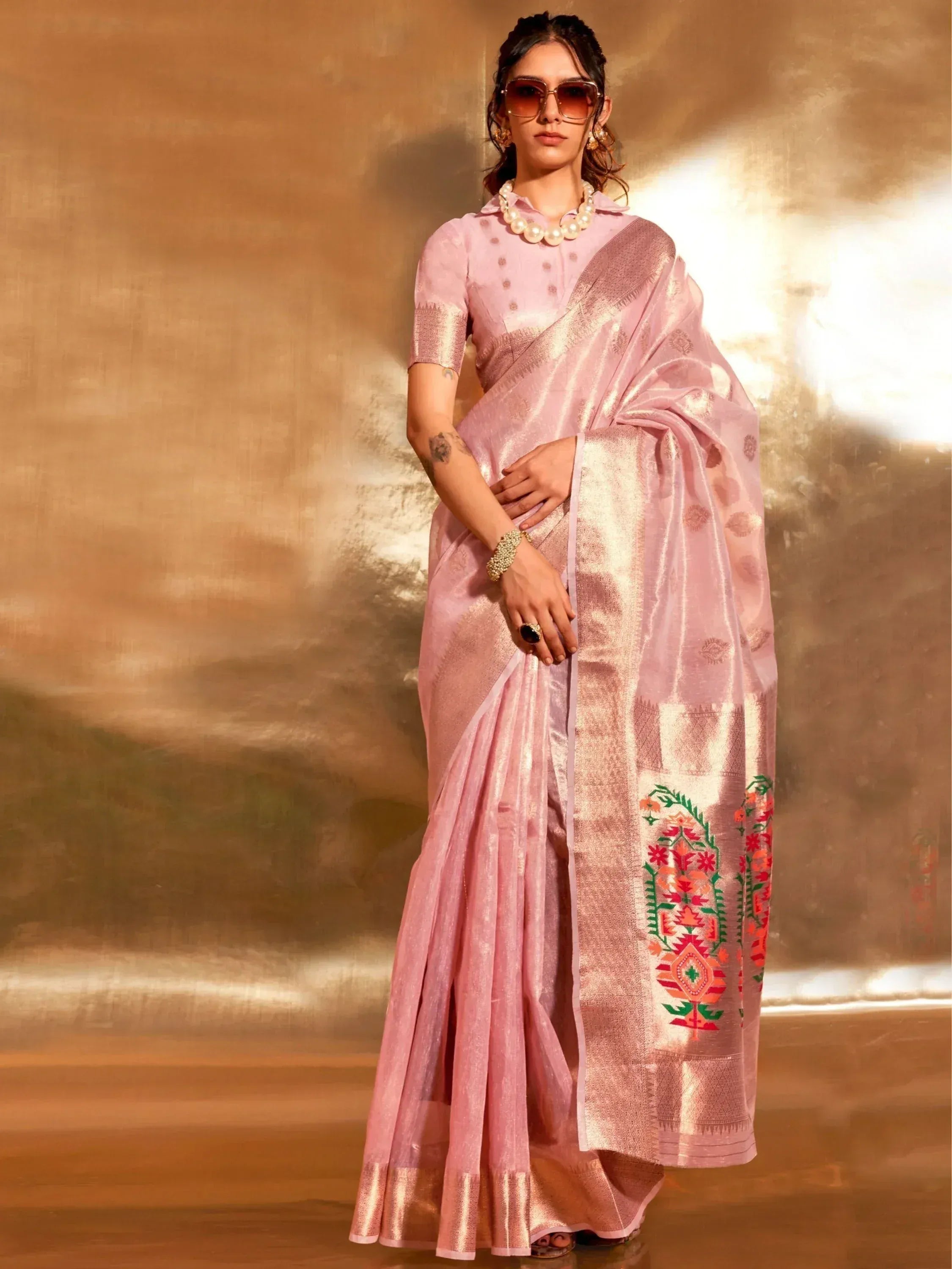 Pink embroidered saree with gold border, styled with pearl necklace and sunglasses for ethnic wear