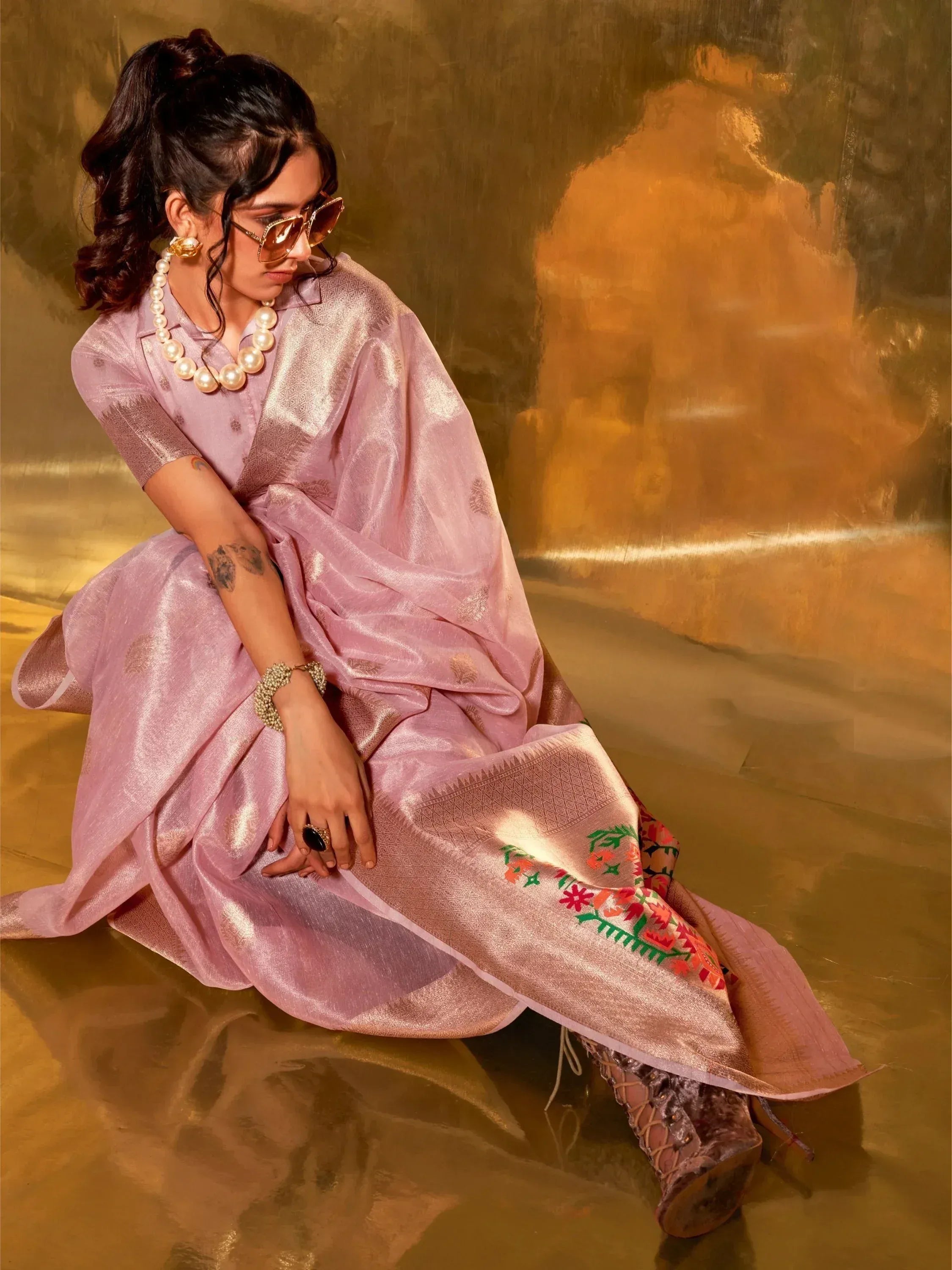Woman in pink embroidered ethnic saree with pearl jewelry, styled for festive occasions