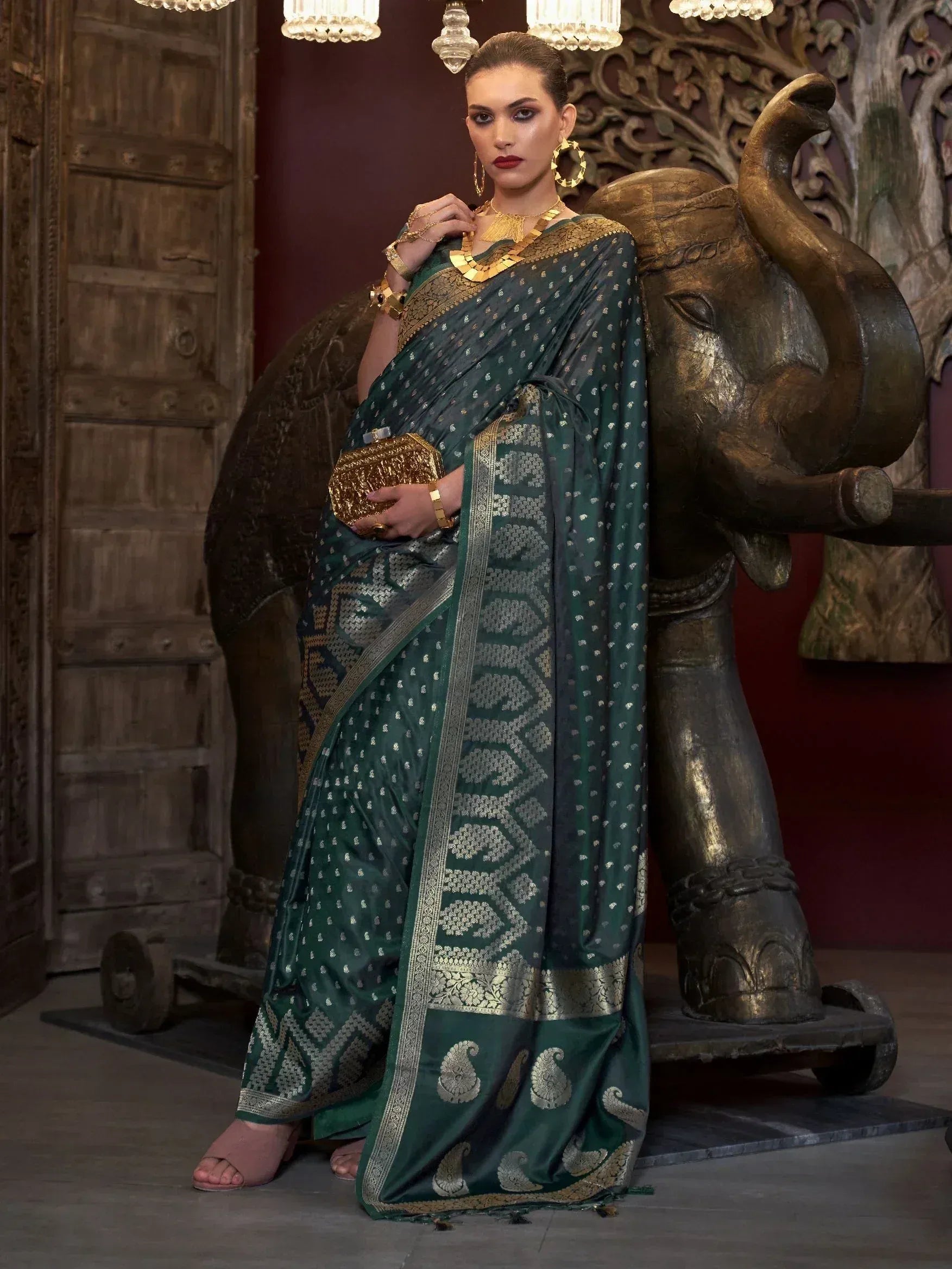 Elegant green designer saree with gold embroidery, paired with statement jewelry, perfect for Indian ethnic occasions.