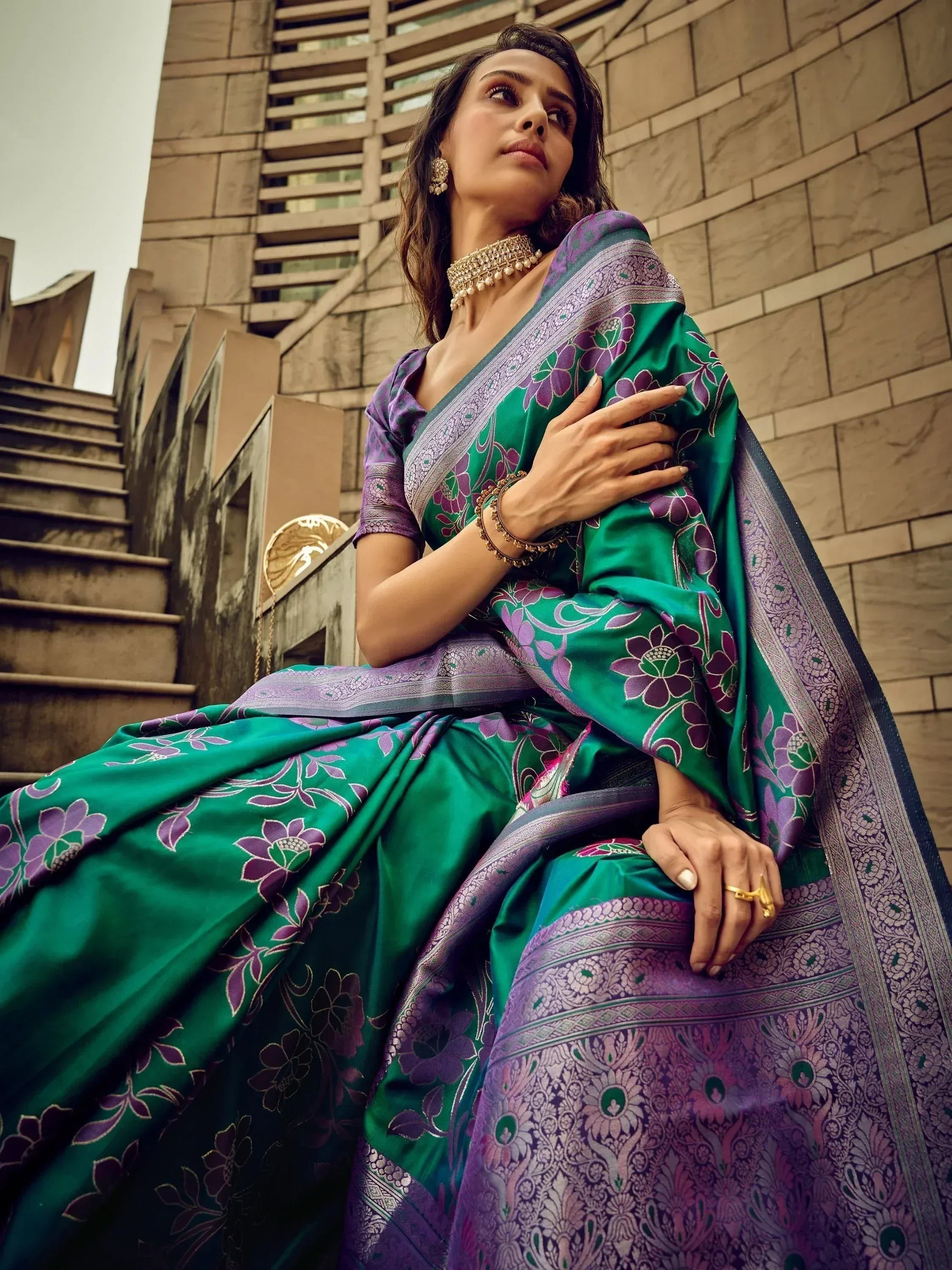 Woman in elegant green and purple floral saree with gold jewelry, styled for ethnic occasions