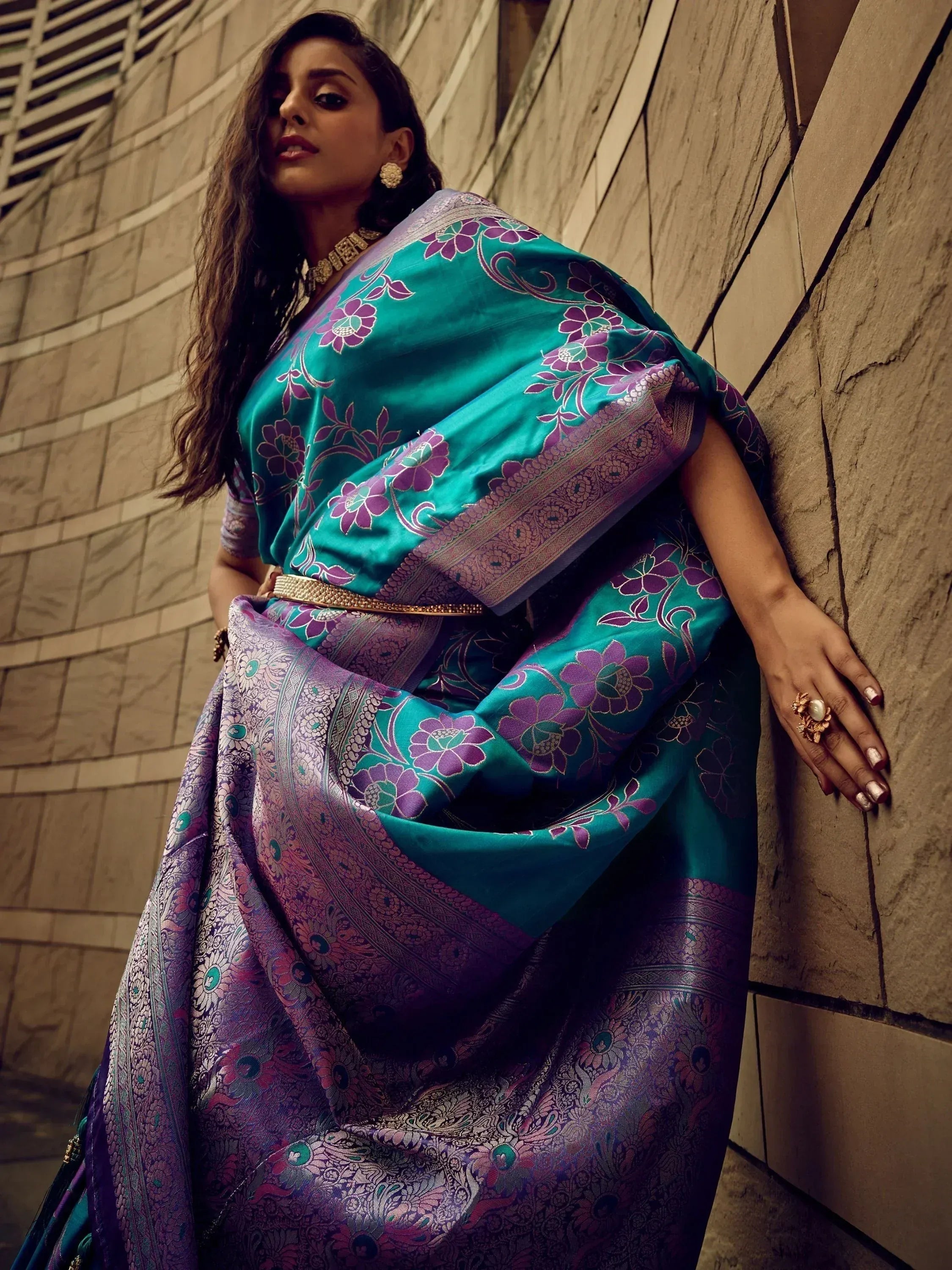 Teal and purple floral saree with intricate border, styled with gold jewelry for ethnic occasions
