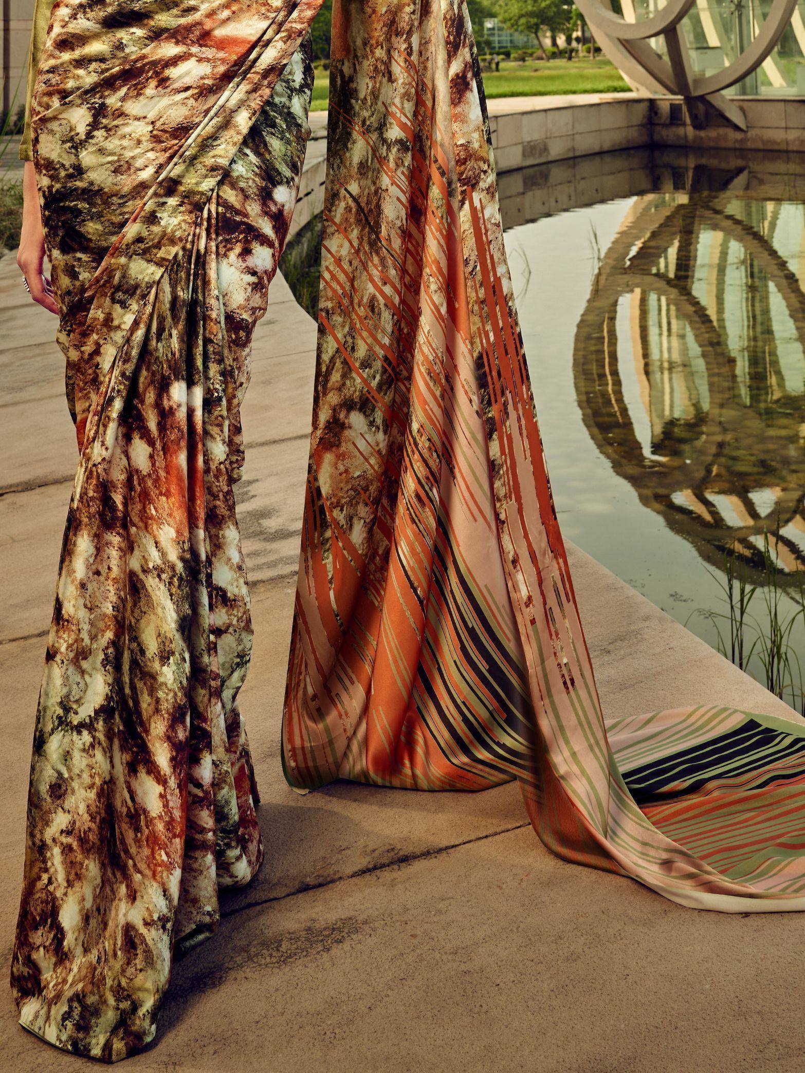 Woman in designer saree with abstract print, standing by water feature, ethnic wear fashion