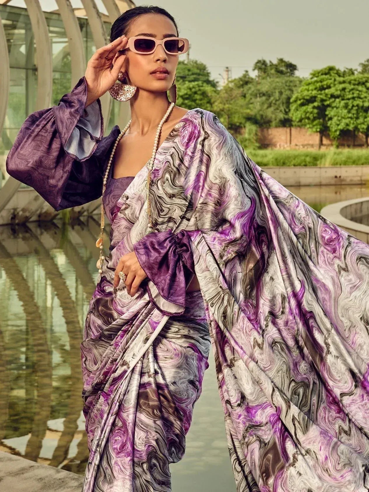 Purple marble print saree with puff sleeves, styled with pearl necklace and pink sunglasses
