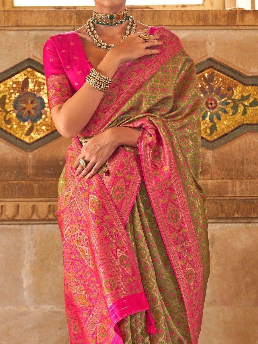 Pink and green designer saree with intricate patterns, paired with traditional jewelry for ethnic wear