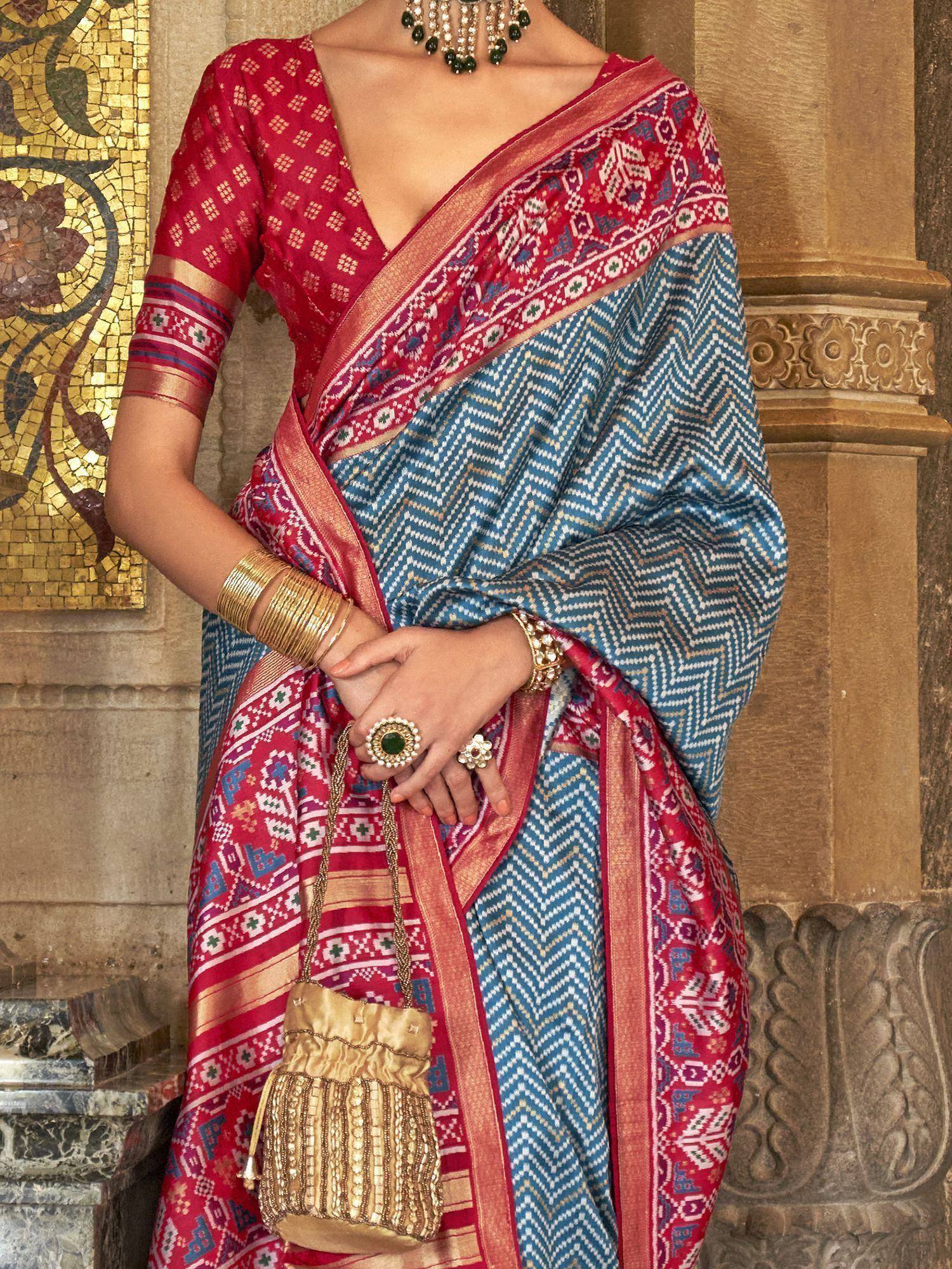 Blue and red ethnic saree with geometric patterns, gold jewelry, and traditional blouse for Indian wear