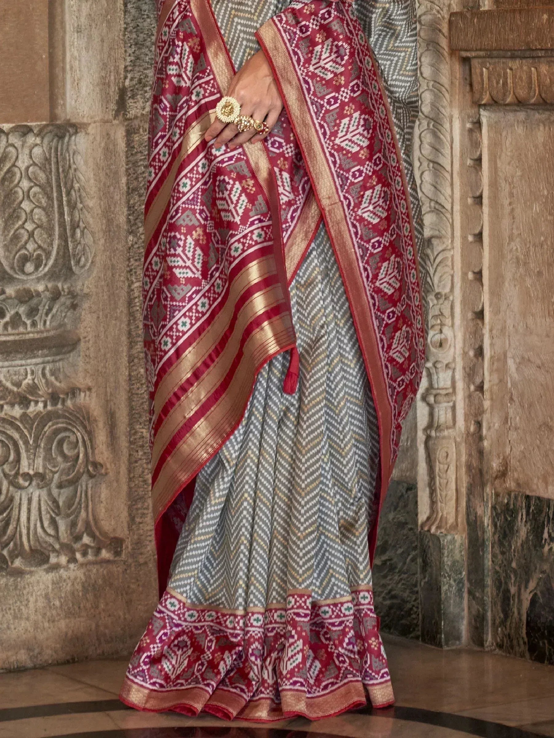 Grey and maroon ethnic saree with geometric patterns and gold zari border, styled with traditional jewelry