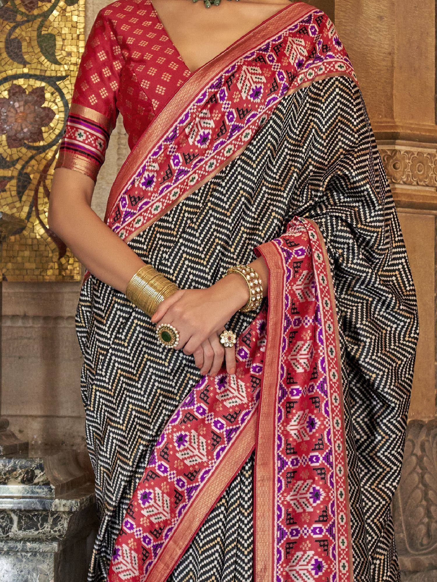 Black and red ethnic saree with geometric print and vibrant border, paired with matching blouse for traditional Indian wear