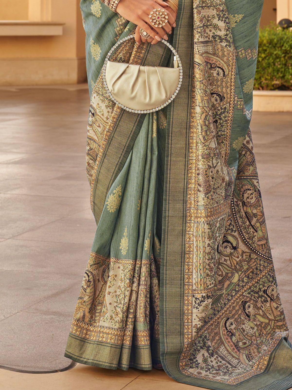 Green printed saree with intricate ethnic motifs and embellished clutch, perfect for Indian ethnic wear occasions