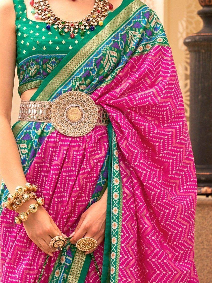 Vibrant pink and green ethnic saree with geometric print, statement belt, and traditional jewelry