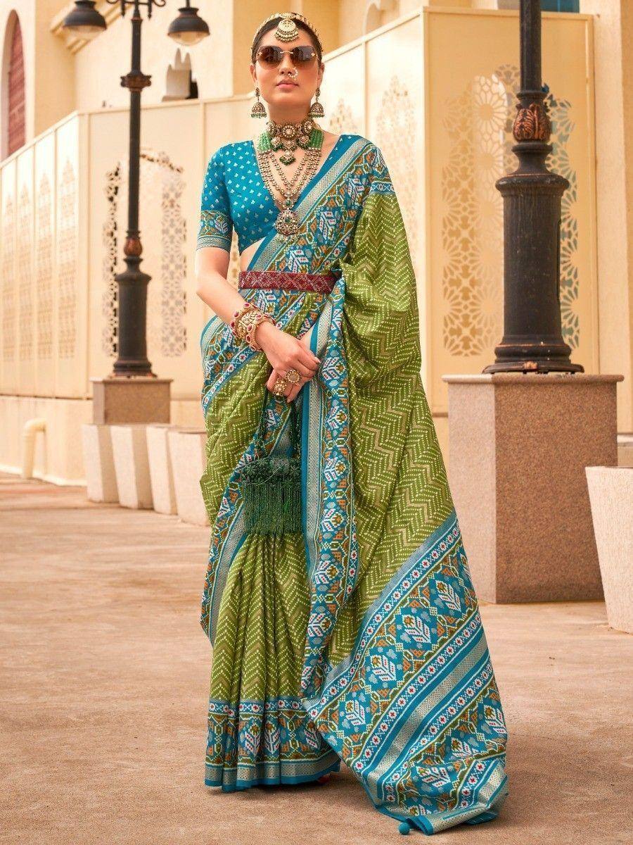 Woman in green and blue printed saree with ethnic jewelry, perfect for Indian festive occasions