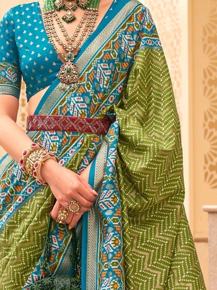 Green and blue printed saree with ethnic jewelry, perfect for Indian festive occasions