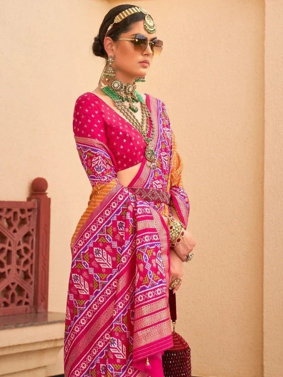 Vibrant pink ethnic saree with geometric print, paired with designer jewelry and sunglasses for a modern Indian look