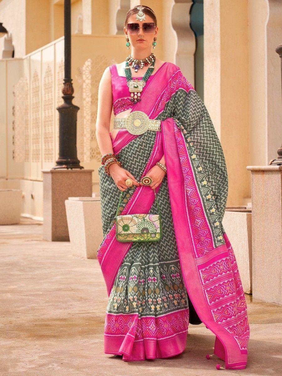 Pink and green ethnic saree with intricate patterns and traditional jewelry