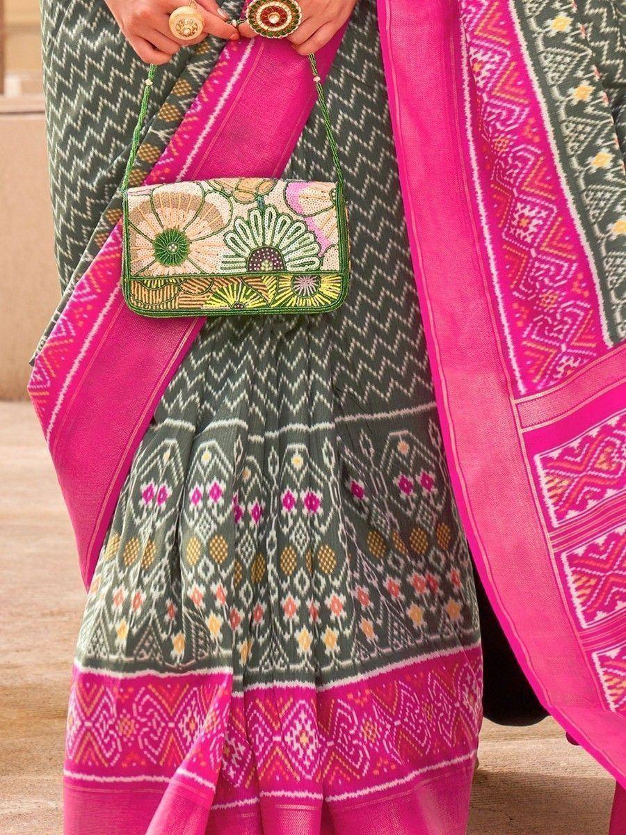 Green and pink ethnic saree with floral embroidered clutch, perfect for Indian festive wear