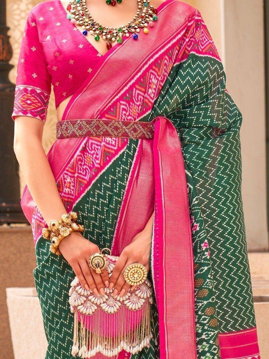 Pink and green ethnic saree with intricate patterns and traditional jewelry