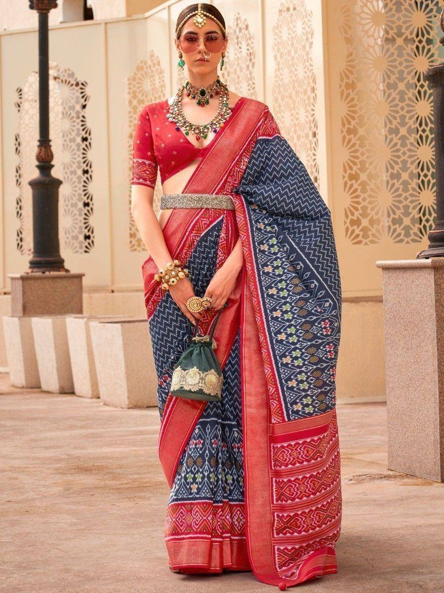 Woman in red and navy blue printed saree with ethnic jewelry and designer blouse