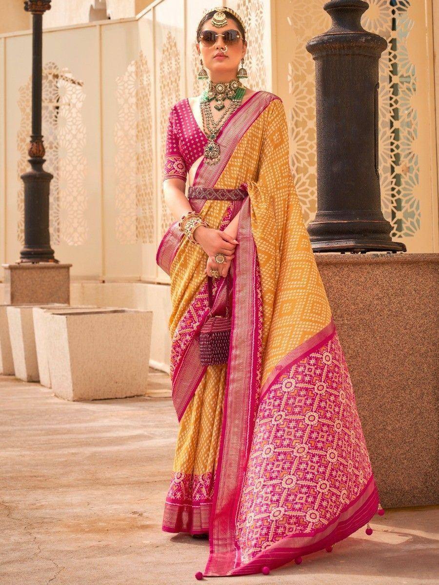 Yellow and pink printed saree with ethnic jewelry, perfect for Indian weddings and festive occasions.