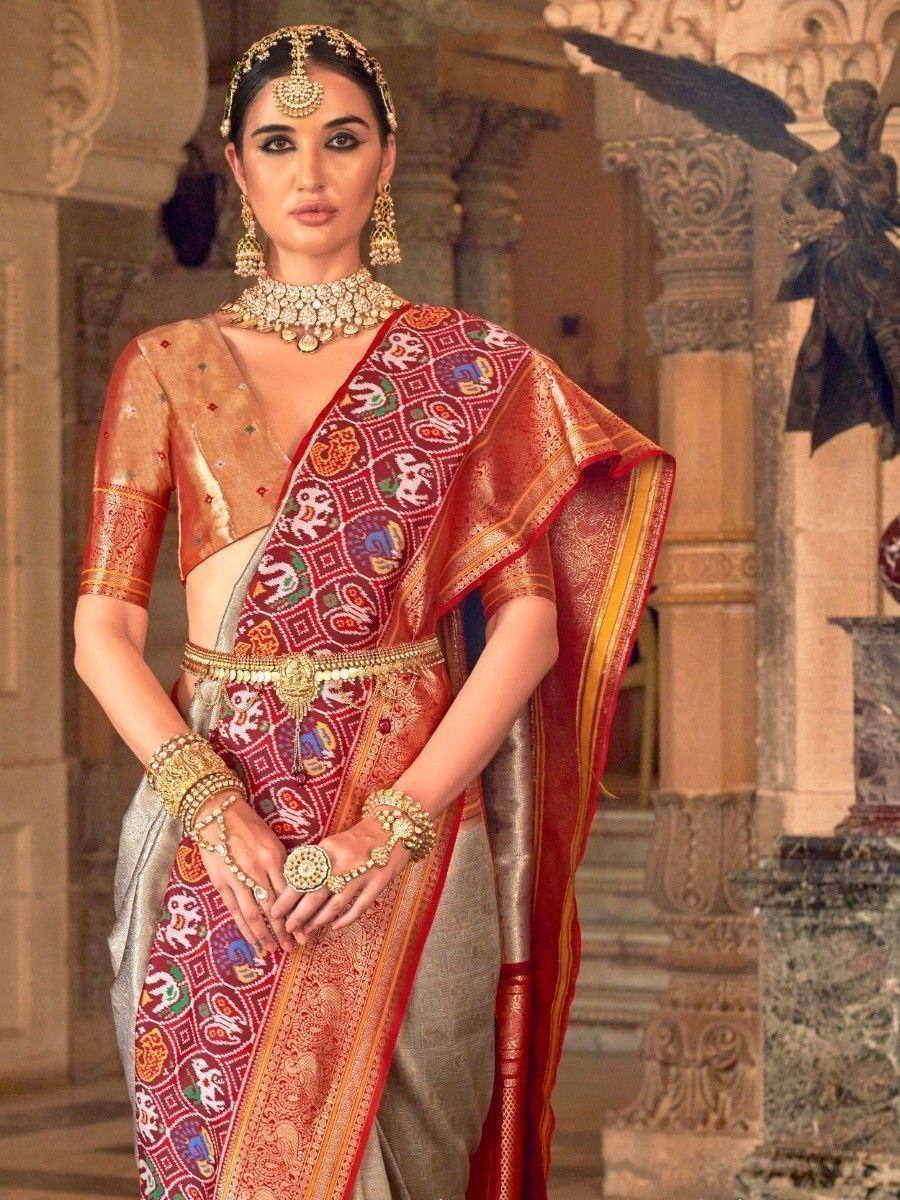 Woman in designer ethnic saree with intricate embroidery, gold jewelry, and traditional Indian attire