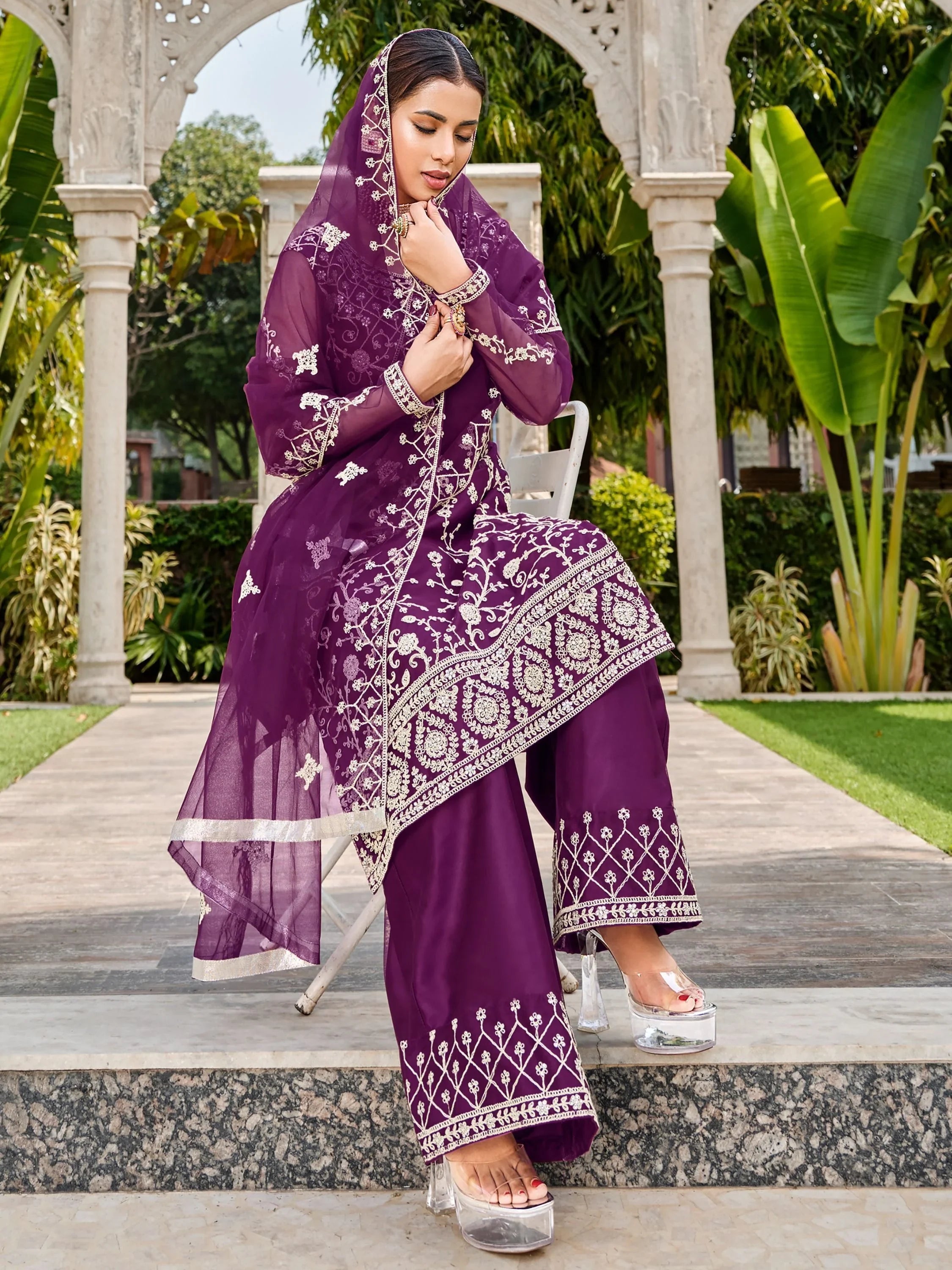 Woman in purple embroidered salwar kameez with dupatta, outdoor garden setting