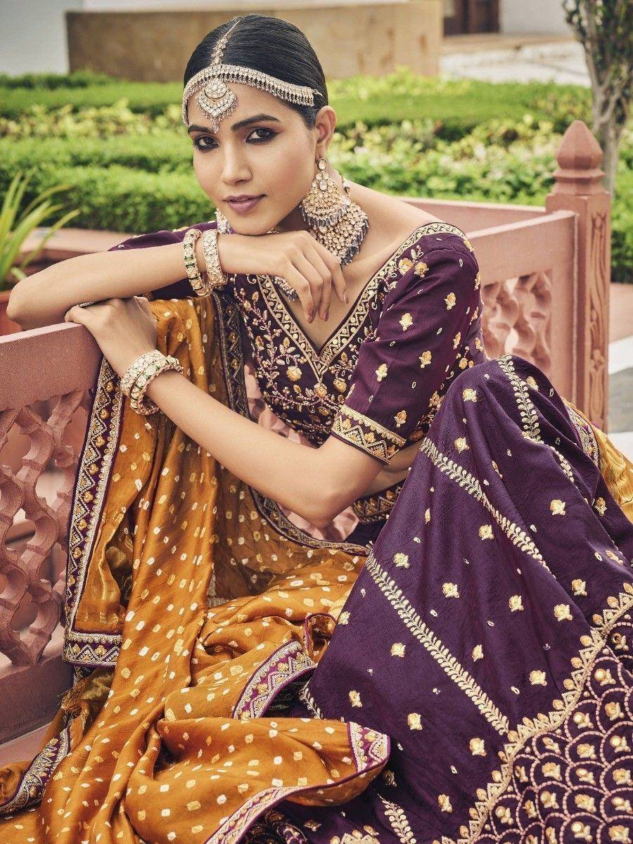 Elegant purple and gold embroidered lehenga choli with traditional jewelry, perfect for Indian ethnic occasions.