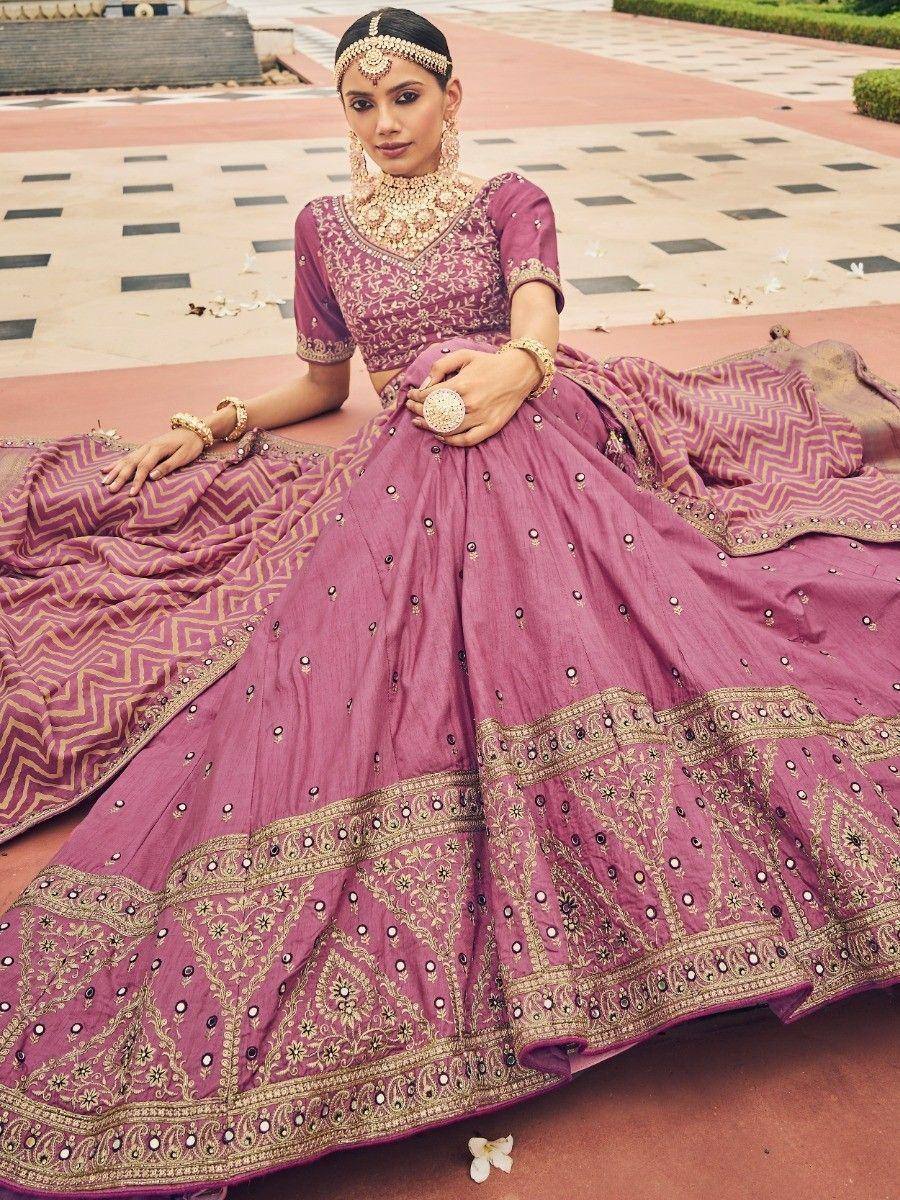 Elegant mauve lehenga choli with gold embroidery and mirror work, perfect for Indian weddings and festive occasions.