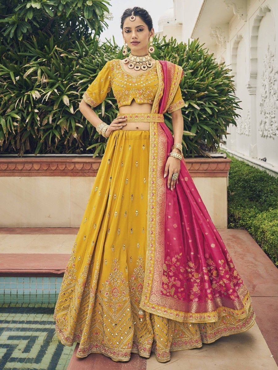 Yellow and pink embroidered lehenga choli with matching dupatta, perfect for Indian weddings and festive occasions.