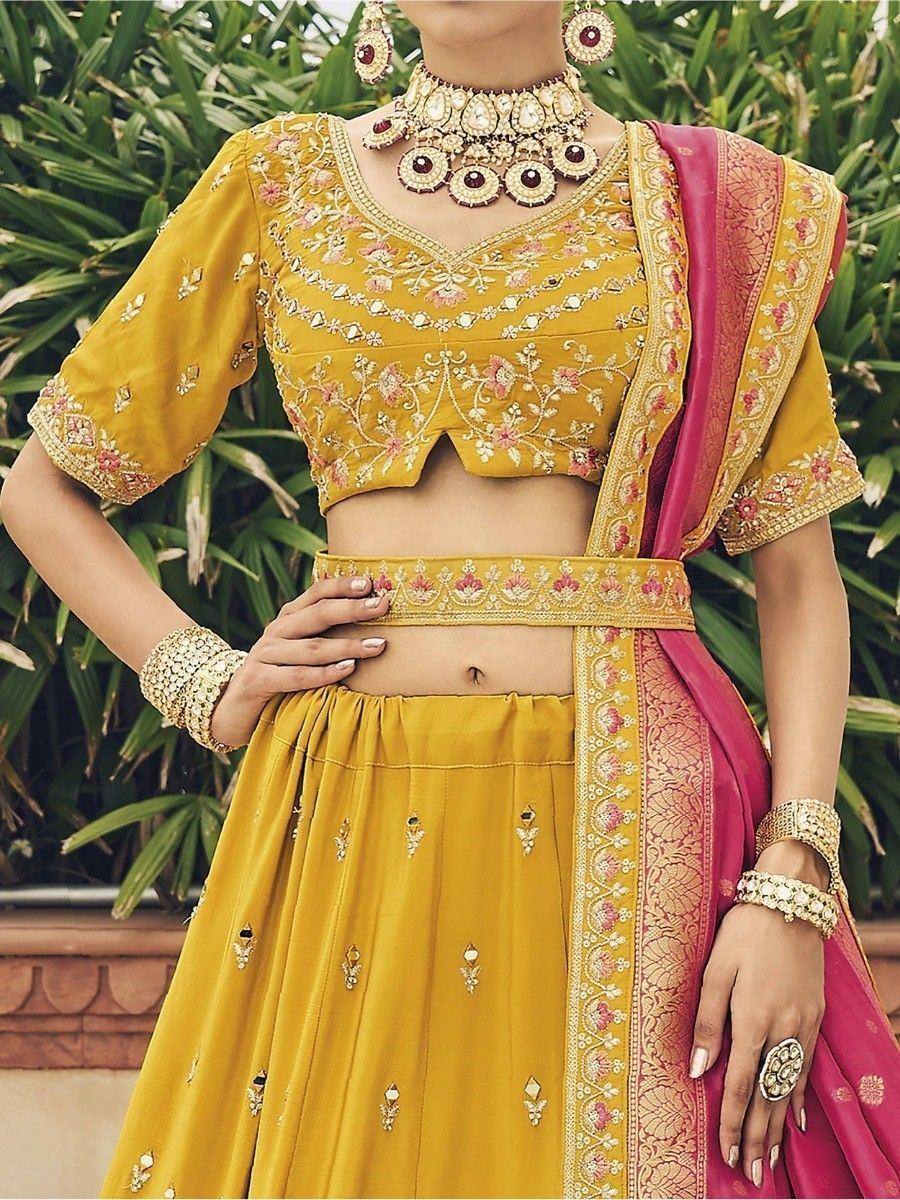 Yellow embroidered lehenga choli with pink dupatta, perfect for Indian weddings and festive occasions