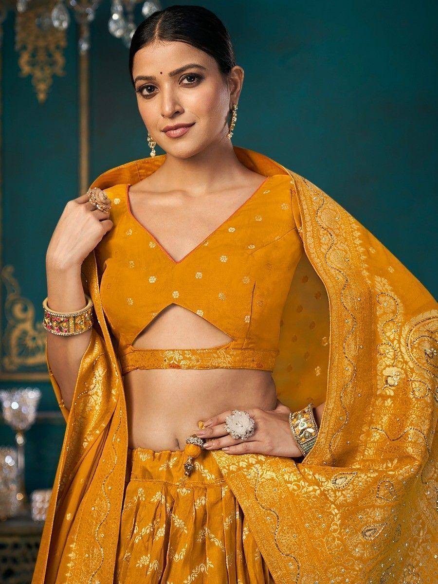 Mustard yellow designer lehenga choli with floral embroidery and cut-out blouse, perfect for Indian ethnic occasions.